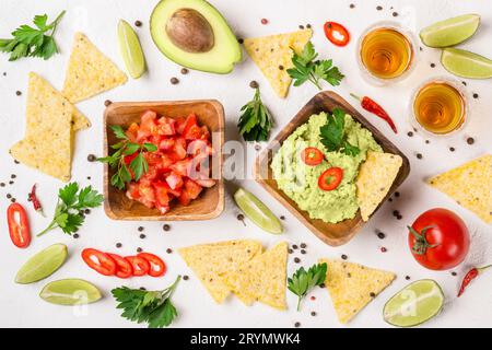 Auswahl an mexikanischen Speisen: Guacamole-Sauce, Salsa, Chips und Tequila mit Limette Stockfoto