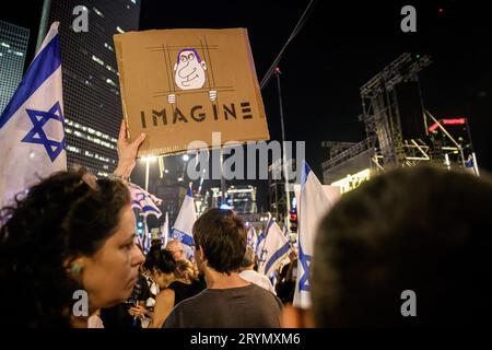 Tel Aviv, Israel. September 2023 30. Ein Demonstrant hält ein Plakat mit einem Karikaturfilm, der Premierminister Benjamin Netanjahu hinter Gittern zeigt, auf dem während einer Demonstration gegen die Justizreform "Imagine" steht. Quelle: SOPA Images Limited/Alamy Live News Stockfoto