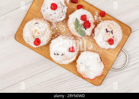 Hausgemachte Fruchtmuffins, bestreut mit Puderzucker und frischen Himbeeren Stockfoto