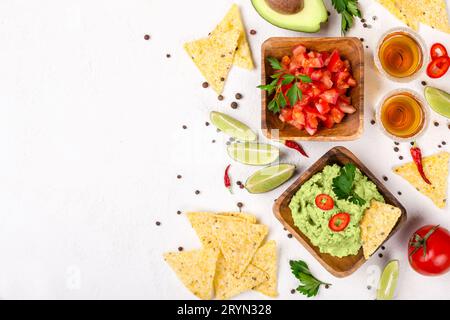 Mexikanische Auswahl: Guacamole-Sauce, Salsa, Chips und Tequila mit Limette auf weißem Hintergrund Stockfoto