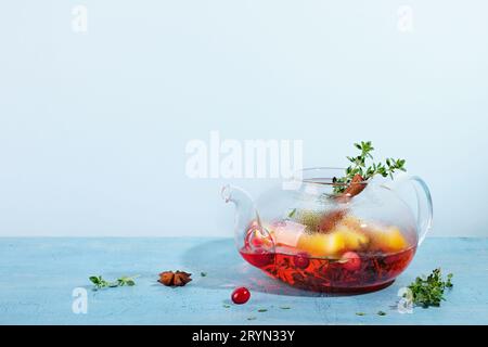 Immunitätssteigerungsgetränk. Wintertee mit Preiselbeeren, Orangen, Hibiskus und Gewürzen in einer Teekanne aus Glas Stockfoto