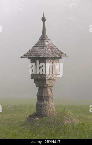 Der Schrein am Wegesrand im herbstlichen Nebel Stockfoto