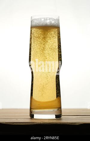 Goldenes Bier mit Blasen in einem transparenten Glas. Stockfoto