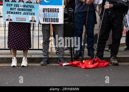 London, Großbritannien. Oktober 2023. Vertreter der Hongkonger, Südmongolier, Tibeter und Uiguren treten während der gemeinsamen Kundgebung vor der chinesischen Botschaft in London auf eine chinesische Nationalflagge. Hongkonger, Südmongolier, Tibeter und Uiguren hielten am Nationalfeiertag der Volksrepublik China jährlich eine gemeinsame Kundgebung und einen marsch ab, um gegen die Verletzung der Menschenrechte durch die Regierung der Kommunistischen Partei Chinas zu protestieren. Die Kundgebung rief die Öffentlichkeit in Großbritannien dazu auf, die Menschenrechte in China zu verteidigen. Quelle: SOPA Images Limited/Alamy Live News Stockfoto