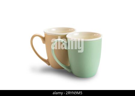 Ansicht von zwei leeren Keramikkkaffeetassen braun und grün isoliert auf weißem Hintergrund. Stockfoto