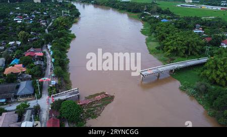 Luftaufnahme einer beschädigten Straßenbrücke über einen Fluss, nachdem das Hochwasser den Asphalt weggespült hatte. Gebrochene Brücke nach Sturzfluten in der Regenzeit. Stockfoto