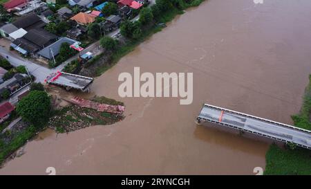 Luftaufnahme einer beschädigten Straßenbrücke über einen Fluss, nachdem das Hochwasser den Asphalt weggespült hatte. Gebrochene Brücke nach Sturzfluten in der Regenzeit. Stockfoto