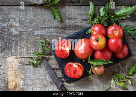 Bio gesunde rohe, reife rosa Tomaten auf einem Küchentisch. Das Konzept der Speisekarte und Ernte. Draufsicht Flat Lay bac Stockfoto