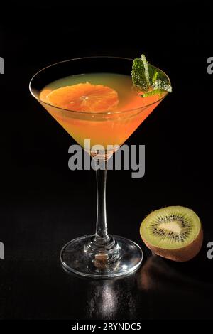 Orangengelee mit Limettenstücken im Glas, mit Minzblättern in Schwarz belegt Stockfoto