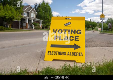 Calgary, Alberta, Kanada. Mai 29. 2023. Vorderansicht eines Hinweisschilds für die Wahlen zum Wahlort Alberta, gelber doppelseitiger Bodenständer. Stockfoto