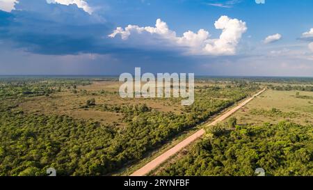 Aus der Vogelperspektive mit Regenwolken ein blauer Himmel der Transpantaneira-Schotterstraße, die das North Pantanal We überquert Stockfoto