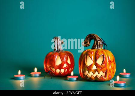 Halloween Komposition mit diy Keramik Kürbisse Jack Laterne und Kerzen auf blaugrünem Hintergrund Stockfoto