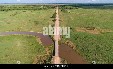 Luftaufnahme der Transpantaneira-Feldstraße, die einen Fluss durch eine Holzbrücke überquert, North Pantanal Wetland Stockfoto