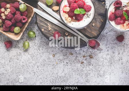 Frische Himbeeren mit Joghurt oder Sahne in Gläsern. Sommer Stockfoto