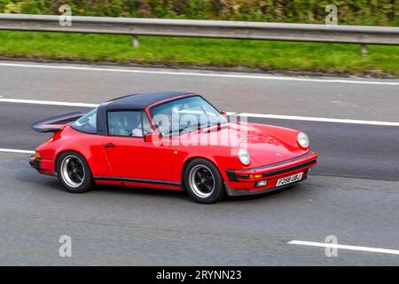 Porsche Carrera Targa Sport Red Car Coupe Benziner der 1988 80er-Achtziger-Jahre, 3164 ccm; Fahrt mit Geschwindigkeit auf der Autobahn M6 in Greater Manchester, Großbritannien Stockfoto