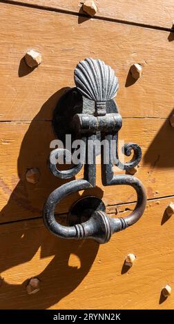 Braune Tür mit klopfendem Stahl in Nahaufnahme an der alten Vintage-Fassade Stockfoto
