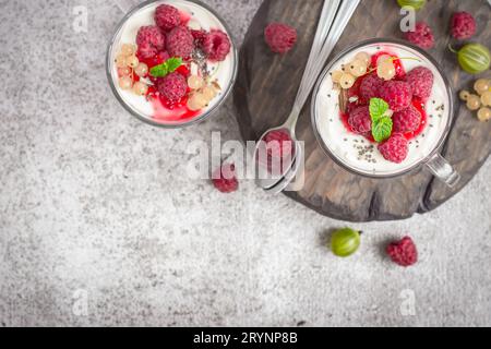 Natürliches gesundes Dessert oder Frühstück mit natürlichem Joghurt im Glasbecher und Reifen Beeren Stockfoto