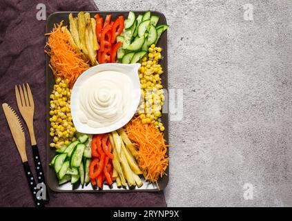 Hausgemachte Mayonnaise-Sauce und buntes Gemüse. Russische Salatziege im Garten. Draufsicht mit Kopierbereich Stockfoto