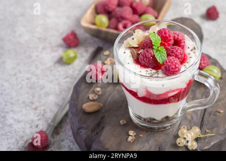 Glas mit Himbeeren, Müsli und Joghurt in Schichten Stockfoto