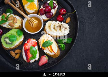 Verschiedene süße Snacks im Sommer. Bruschetta oder Sandwiches mit Früchten Stockfoto