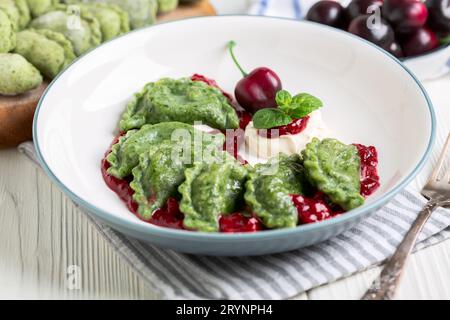 Kirschknödel (Pierogien) mit Kirschsauce aus nächster Nähe. Stockfoto