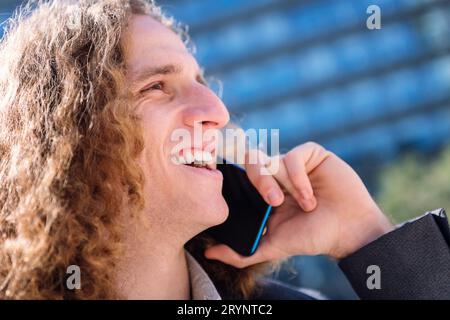Der Mann lachte, während er mit dem Handy sprach Stockfoto