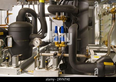 Isolierte Rohre und Manometer an einer Maschine Stockfoto