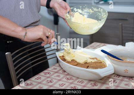 Die Hände der Frau bereiten Tiramisu vor. Typisch italienisches Dessert Stockfoto