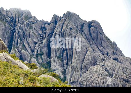 Malerische zerklüftete Granitberge der Serra da Mantiqueira (Mantiqueira Mountain Range) mit grasbewachsenen Teilen vor hellem Hintergrund Stockfoto