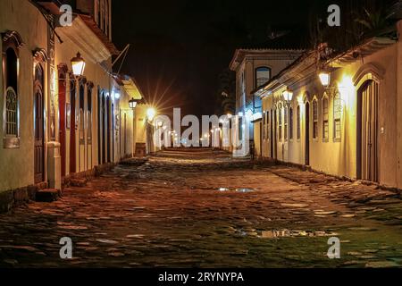 Stimmungsvoller Nachtsicht auf beleuchtete Straßen und Gebäude im historischen Zentrum von Paraty, Brasilien, UNESCO-Weltkulturerbe Stockfoto