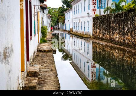 Überflutete enge Straße bei Flut mit Reflexionen von Kolonialhäusern in der historischen Stadt Paraty, Brasilien, UNESCO World Heritag Stockfoto