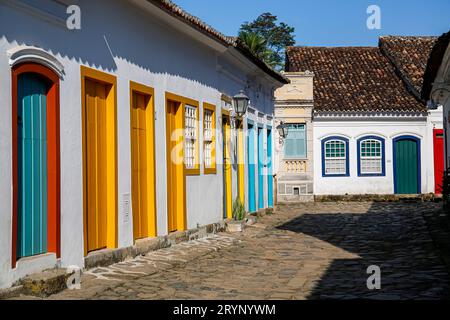 Typische kopfsteingepflasterte Straße mit bunten kolonialen Gebäuden in der späten Nachmittagssonne in der historischen Stadt Paraty, Brasilien Stockfoto