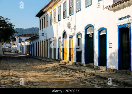 Typische Kopfsteinpflasterstraße mit Kolonialgebäuden im Nachmittagslicht in der historischen Stadt Paraty, Brasilien Stockfoto