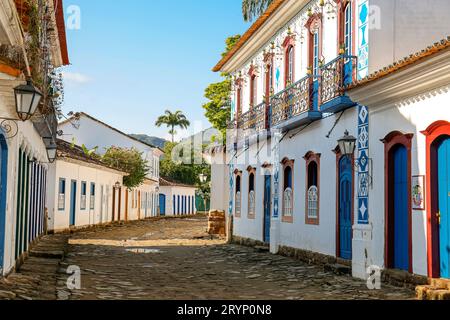 Blick auf eine kopfsteingepflasterte Straße mit kunstvoll dekorierten Fassaden in der historischen Stadt Paraty, Brasilien Stockfoto