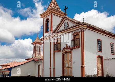 Blick auf die historische Kirche in weiß und rot, mit blauem Himmel und weißen Wolken, Diamantina, Minas Gerais, Stockfoto
