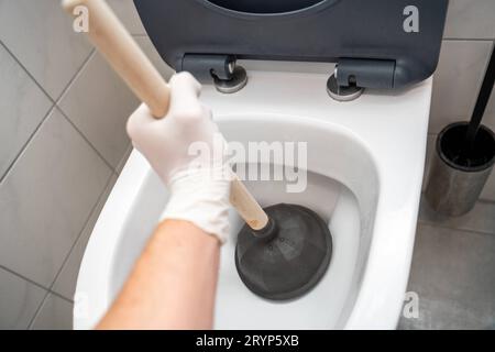 Bayern, Deutschland. September 2023 29. Hand versucht eine Verstopfung in der Toilette im Badezimmer zu lösen mit einer Saugglocke Credit: Imago/Alamy Live News Stockfoto
