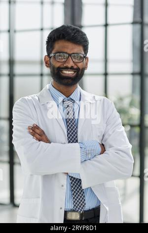 Porträt eines lächelnden männlichen Arztes, der in einem Krankenhausgang steht Stockfoto