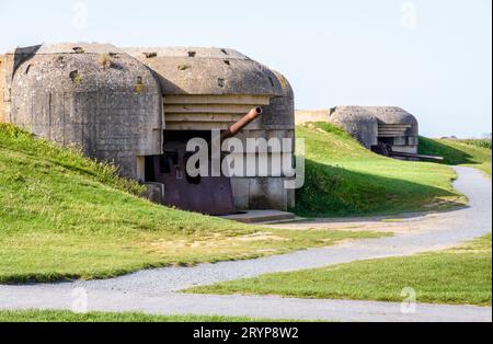 Zwei Bunker, die eine 150-mm-Kanone in der Longues-sur-Mer-Batterie in der Normandie halten, eine deutsche Küstenartillerie-Batterie aus dem Zweiten Weltkrieg, die Teil der Atlantischen Mauer ist. Stockfoto