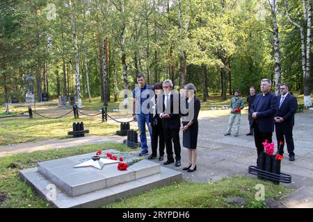 PRODUKTION - 12. September 2023, Russland, Sologubowka: Eine Gruppe von Menschen, darunter Hermann Krause (3. V.l.), Büroleiter der war Graves Commission in Russland, und Michael Schwarzkopf (2. V.l.), Pfarrer von St. Peterskirche in St. Petersburg, stehen Sie vor einer Gedenkstätte auf dem Militärfriedhof Sologubovka bei St. Petersburg. 525 Soldaten der deutschen Wehrmacht, deren Knochen in den letzten drei Jahren im Nordwesten Russlands geborgen wurden, finden ihre letzte Ruhestätte auf dem Militärfriedhof. (An dpa-Korr: "Gedenken an die Toten des Weltkriegs inmitten neuer Kriegszeiten") Stockfoto