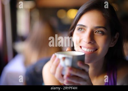 Glücklicher Träumer, der Kaffee in einem Restaurant trinkt Stockfoto