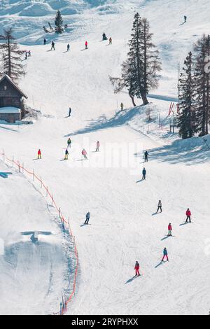 Große Gruppe von Skifahrern, die einen sonnigen Wintertag auf der Skipiste genießen, unerkennbare Menschen, die in Slowenien Ski fahren Stockfoto