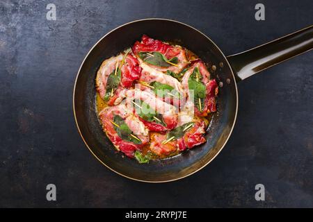 Traditionelles italienisches gebratenes Schweinefleisch Saltimbocca alla Romana mit Parmaschinken und Salbeiblättern, serviert als Blick von oben in einer klassischen Pfanne Stockfoto