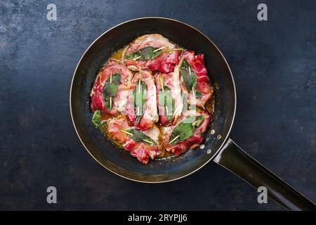 Traditionelles italienisches gebratenes Schweinefleisch Saltimbocca alla Romana mit Parmaschinken und Salbeiblättern, serviert als Blick von oben in einer klassischen Pfanne Stockfoto