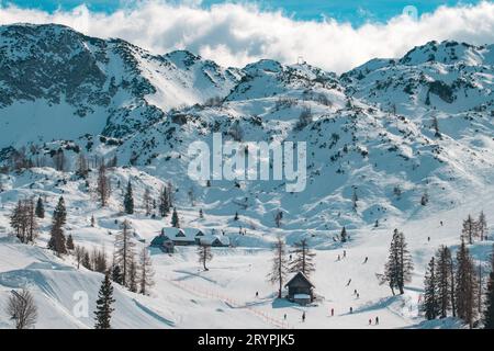 Große Gruppe von Skifahrern, die einen sonnigen Wintertag auf der Skipiste genießen, unerkennbare Menschen, die in Slowenien Ski fahren Stockfoto