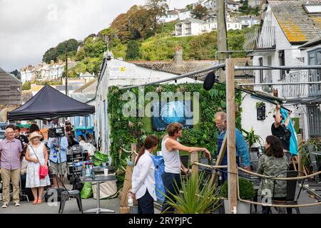 Beyond Paradise BBC-Fernsehserie, Live-Dreharbeiten in Looe Cornwall im September 2023, Schauspieler Kris Marshall und Zahra Ahmadi treten in einer britischen Szene auf Stockfoto