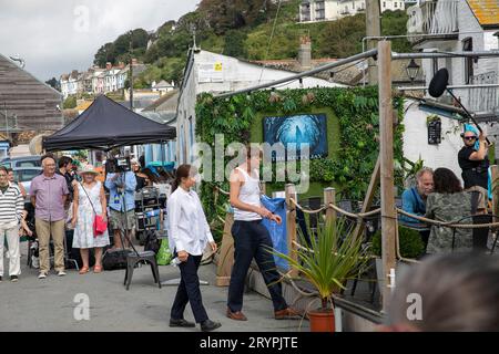 Beyond Paradise BBC-Fernsehserie, Live-Dreharbeiten in Looe Cornwall im September 2023, Schauspieler Kris Marshall und Zahra Ahmadi treten in einer britischen Szene auf Stockfoto