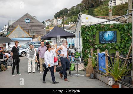 Beyond Paradise BBC-Fernsehserie, Live-Dreharbeiten in Looe Cornwall im September 2023, Schauspieler Kris Marshall und Zahra Ahmadi treten in einer britischen Szene auf Stockfoto