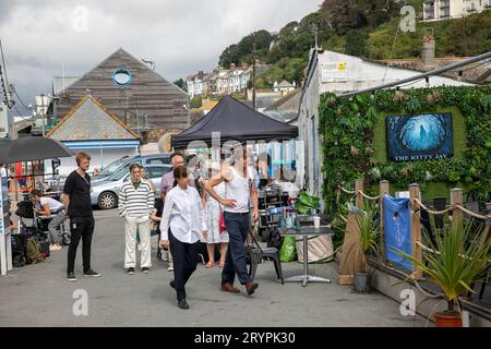 Beyond Paradise BBC-Fernsehserie, Live-Dreharbeiten in Looe Cornwall im September 2023, Schauspieler Kris Marshall und Zahra Ahmadi treten in einer britischen Szene auf Stockfoto