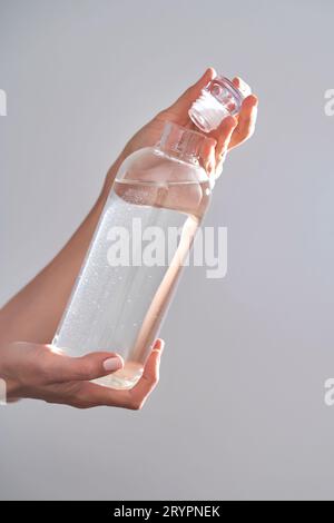 Flasche mit Trinkwasser in weiblichen Händen. Stockfoto