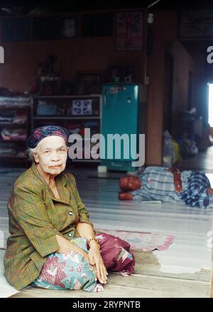 Das 35 mm negative einer Frau, die in einem Heim sitzt, mit Bleichmittel im Gesicht während der Überschwemmung auf dem schwimmenden Dorf Panyee, Thailand, im März 2011 gescannt Stockfoto